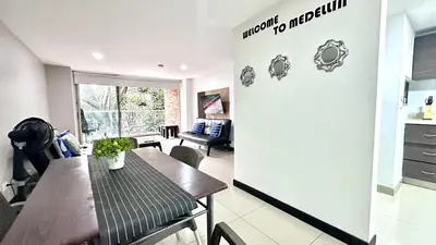 a kitchen and living room with a table and chairs at Apto Moderno en Laureles in Medellín