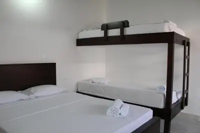 two bunk beds in a room with two white beds at Hotel La Ceiba in Valparaíso