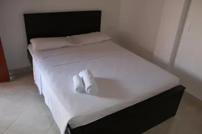 a bed with two towels sitting on top of it at Hotel La Ceiba in Valparaíso
