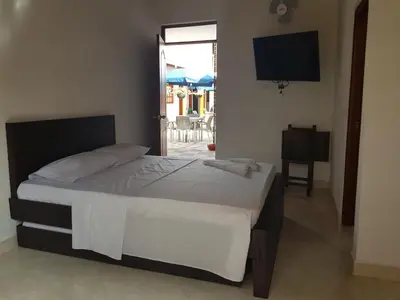 a bedroom with a bed and a television and a patio at Hotel La Ceiba in Valparaíso