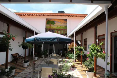 an outdoor patio with tables and an umbrella at Hotel La Ceiba in Valparaíso