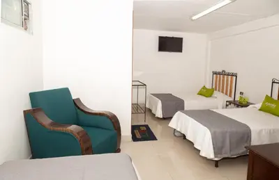 a hotel room with two beds and a blue chair at Ayenda 1131 Casa Valencia in Manizales