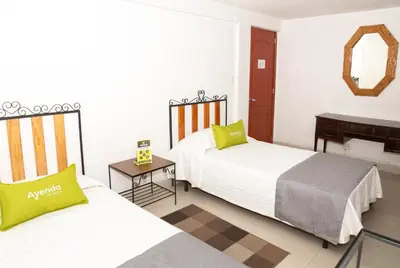 a hotel room with two beds and a piano at Ayenda 1131 Casa Valencia in Manizales