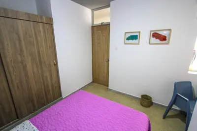 a bedroom with a pink bed and a door at Casa Tuvia in Medellín
