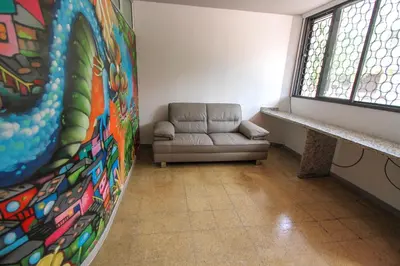 a waiting room with a couch and a painting at Casa Tuvia in Medellín
