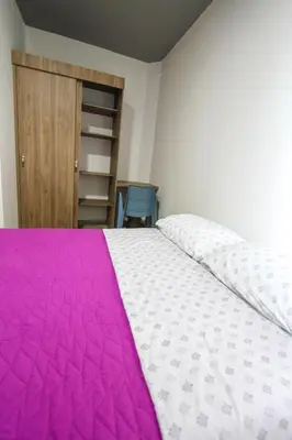 a bedroom with a bed with a pink blanket at Casa Tuvia in Medellín