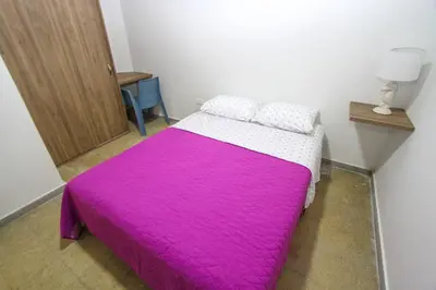 a bedroom with a bed with a pink blanket at Casa Tuvia in Medellín