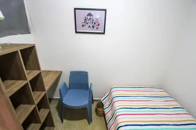 a room with a bed and a blue chair at Casa Tuvia in Medellín
