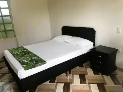 a bed in a room with a black bed frame at La Luna by JR in Mariquita