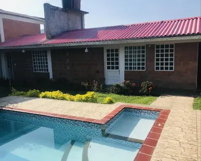 a swimming pool in front of a house with a red roof at La Luna by JR in Mariquita