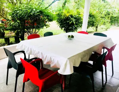 a table with red chairs and a white table cloth at La Luna by JR in Mariquita