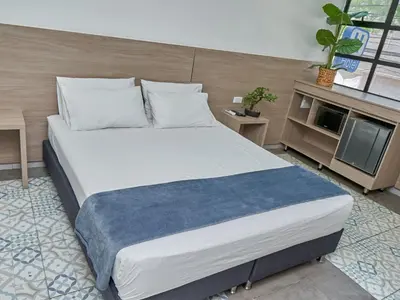 a bedroom with a large white bed in a room at Stanza Hotel Medellin in Medellín