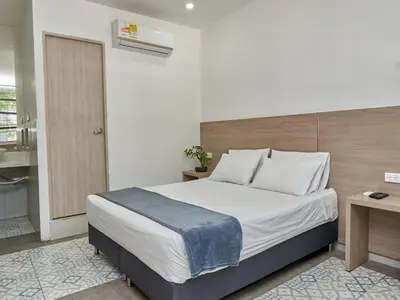 a bedroom with a large bed and a bathroom at Stanza Hotel Medellin in Medellín