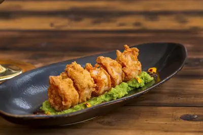 a plate of food with fried chicken on a salad at El Rio Hotel in Doradal