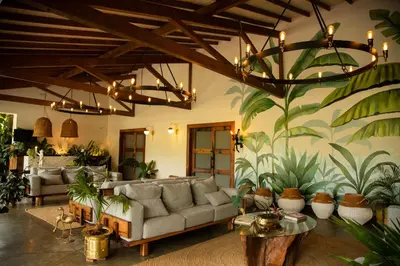 a living room with a couch and plants on the wall at El Rio Hotel in Doradal
