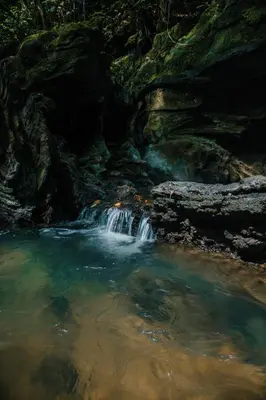 a waterfall in a pool of water in a river at El Rio Hotel in Doradal