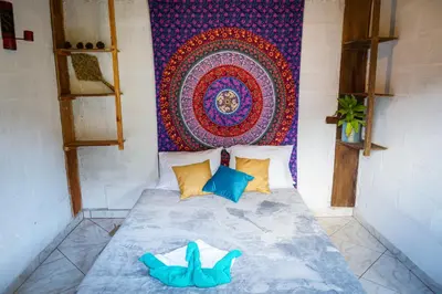a bed in a room with a tapestry on the wall at Creo Ecolodge Jardín in Jardin