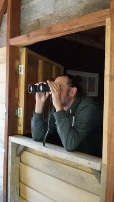 a man taking a picture in a wooden box with a camera at Creo Ecolodge Jardín in Jardin