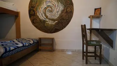 a bedroom with a bed and a chair and a painting on the wall at Creo Ecolodge Jardín in Jardin