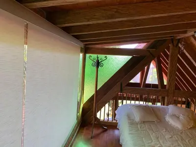 an attic room with a bed and a window at Rancheria Loft Chalet, lago privado in Rionegro