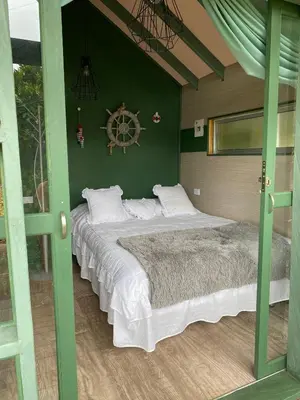 a bedroom with a large bed in a green wall at Rancheria Loft Chalet, lago privado in Rionegro