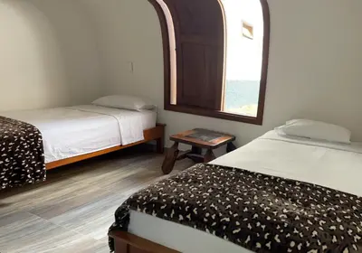a small room with two beds and a window at Apartamento cerca a cascada del Amor,Wifi in Jardin