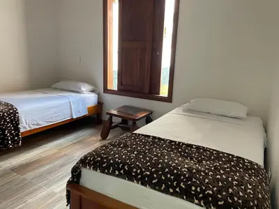 a small room with two beds and a mirror at Apartamento cerca a cascada del Amor,Wifi in Jardin