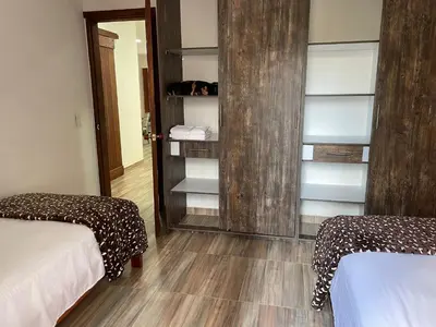 a room with two beds and a closet with shelves at Apartamento cerca a cascada del Amor,Wifi in Jardin