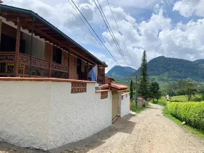 a house on a dirt road with mountains in the background at Apartamento cerca a cascada del Amor,Wifi in Jardin