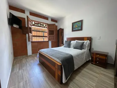 a bedroom with a bed and a television in it at Apartamento cerca a cascada del Amor,Wifi in Jardin