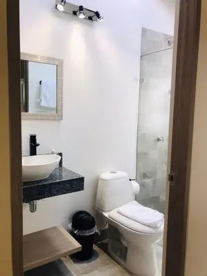 a bathroom with a toilet and a sink and a mirror at Hotel & Golf Isak Aeropuerto in Rionegro