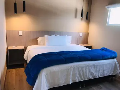 a large bed with a blue blanket on it at Hotel & Golf Isak Aeropuerto in Rionegro