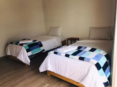 two twin beds in a room with at Hotel & Golf Isak Aeropuerto in Rionegro