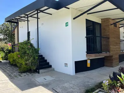 a white house with a staircase and a balcony at Hotel & Golf Isak Aeropuerto in Rionegro