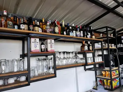 a shelf filled with lots of bottles and glasses at Hotel & Golf Isak Aeropuerto in Rionegro