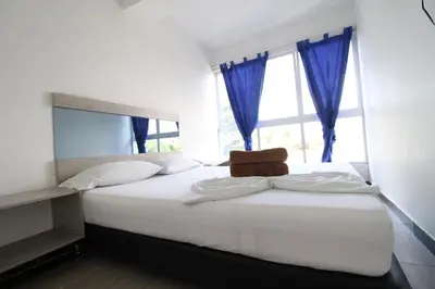 a bedroom with a large white bed with a window at HOTEL PORTÓN ESTADIO in Medellín