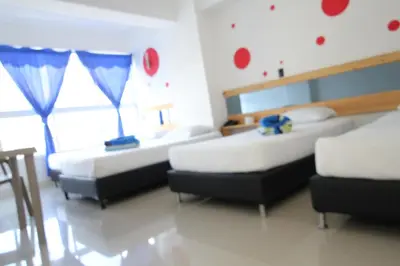 a bedroom with two beds and a window at HOTEL PORTÓN ESTADIO in Medellín
