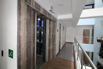 a hallway with a wooden door in a building at HOTEL PORTÓN ESTADIO in Medellín