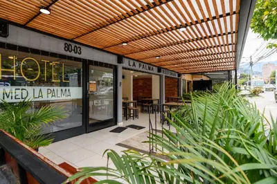 a restaurant with a patio with tables and chairs at Med la palma in Medellín