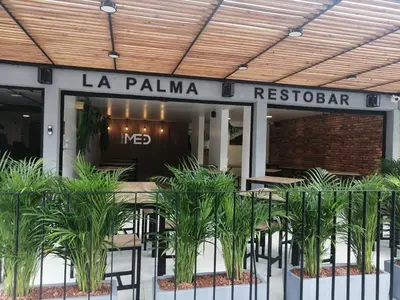 a restaurant with tables and plants in front of it at Med la palma in Medellín