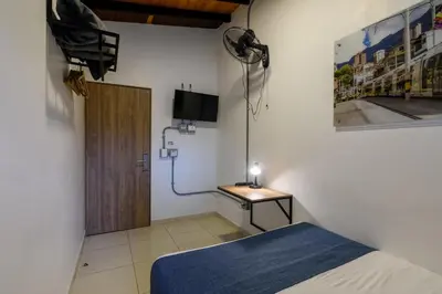 a room with a bed and a television on a wall at Med la palma in Medellín