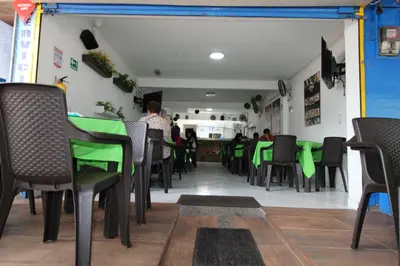 a dining room with green tables and chairs at HOTEL MANAGER OBELISK in Medellín
