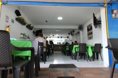 a dining room with green tables and chairs at HOTEL MANAGER OBELISK in Medellín