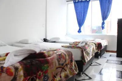 a room with three beds and a window at HOTEL MANAGER OBELISK in Medellín