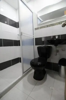 a bathroom with a black toilet and a shower at HOTEL MANAGER OBELISK in Medellín