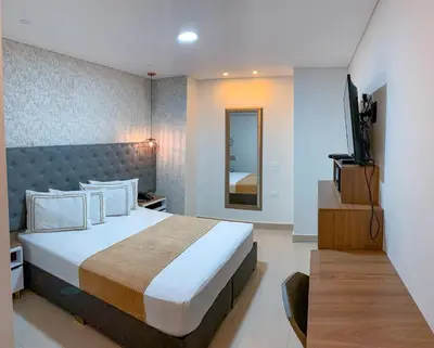 a bedroom with a large bed and a television at Infinity Hotel in Medellín