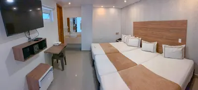 a bedroom with two beds and a flat screen tv at Infinity Hotel in Medellín