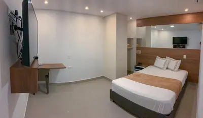a bedroom with a bed and a television in it at Infinity Hotel in Medellín