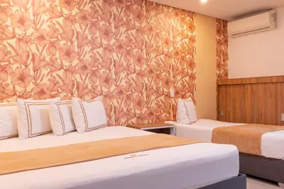 a hotel room with two beds and a wall mural at Infinity Hotel in Medellín