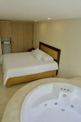 a bedroom with a bed and a bath tub at Hotel San Pedro del Fuerte in Medellín